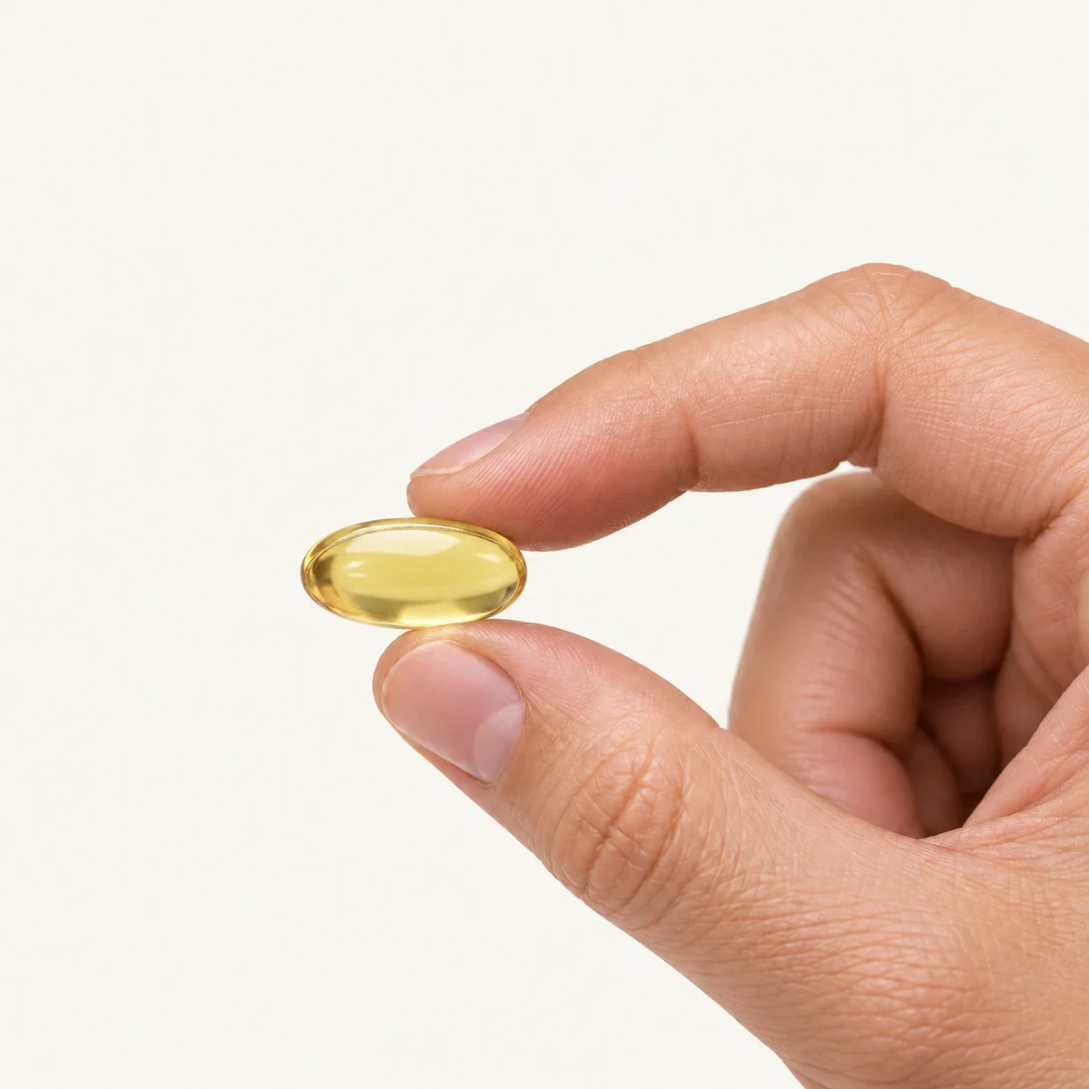Vitamin D3 4000 IU dosage form held between fingertips